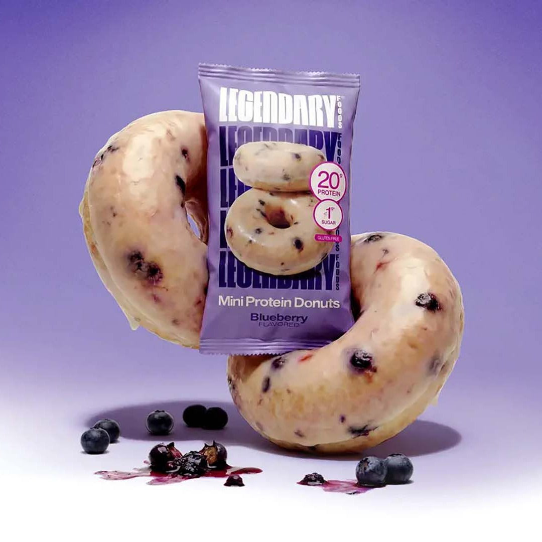 Legendary Blueberry Protein Donuts pack with two glazed donuts and fresh blueberries on purple
