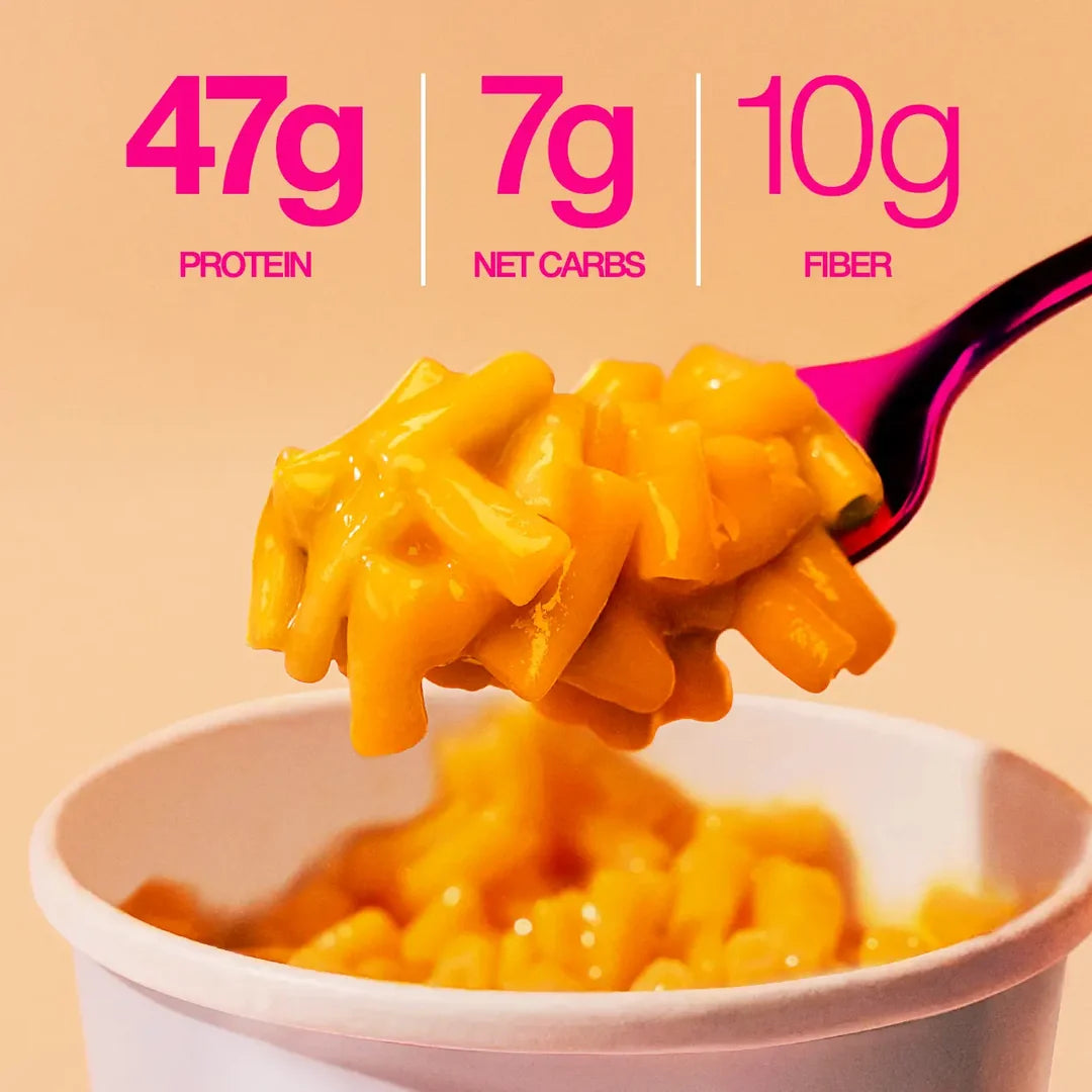 Close-up of Legendary Mac & Cheese protein pasta on a fork above the cup: 47g protein, 7g net carbs, 10g fibre.
