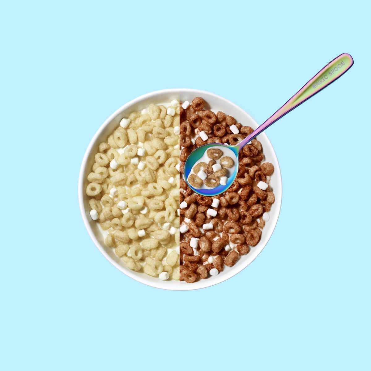 Magic Spoon Protein Cereal bowl mixing plain and cocoa pieces with marshmallows and a spoon of milk