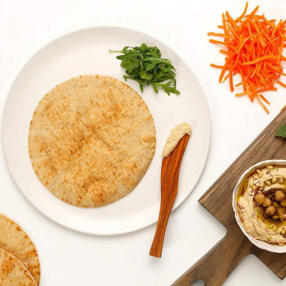 Joseph's Bakery Flax, Oat Bran & Whole Wheat Pita Bread, single pita on a white plate with hummus and carrots