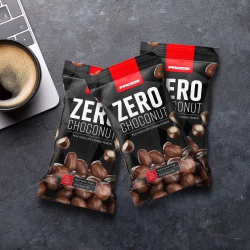 Prozis Zero Choconut bags styled with a cup of coffee on a dark surface