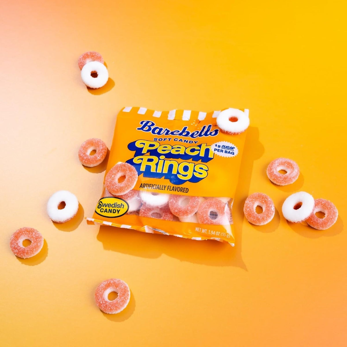 Barebells Soft Candy Peach Rings bag with sugar-coated peach ring gummies on an orange background