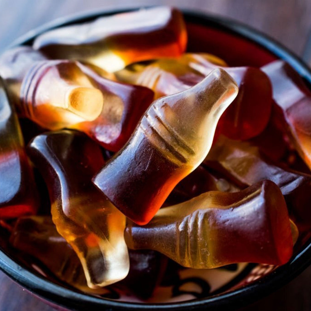 Diablo Sugar Free Cola Bottles, chewy cola-flavoured gummy sweets shown close up in a dark bowl