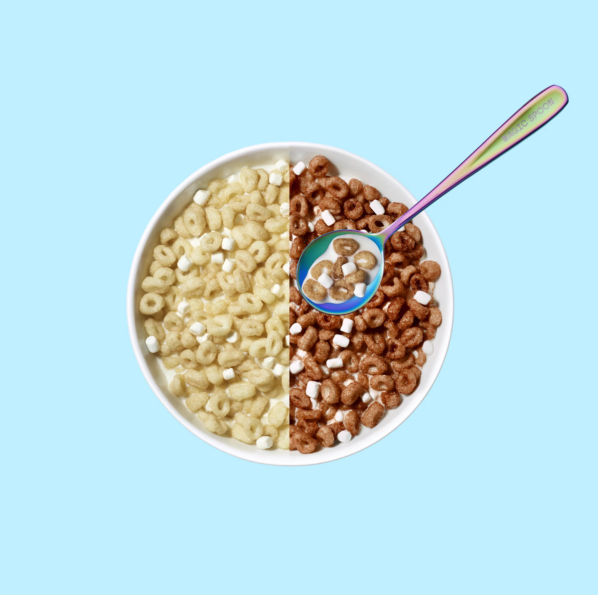 Magic Spoon Protein Cereal bowl mixing plain and cocoa pieces with marshmallows and a spoon of milk