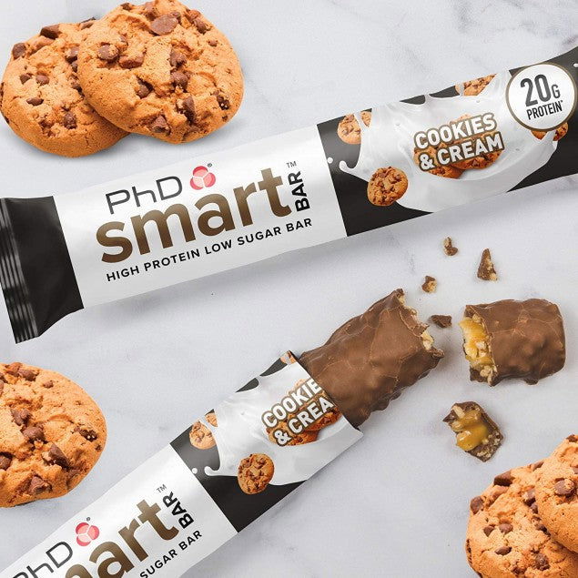 PhD Smart Cookies and Cream bar with melted chocolate and cookies scattered on marble, 20g protein