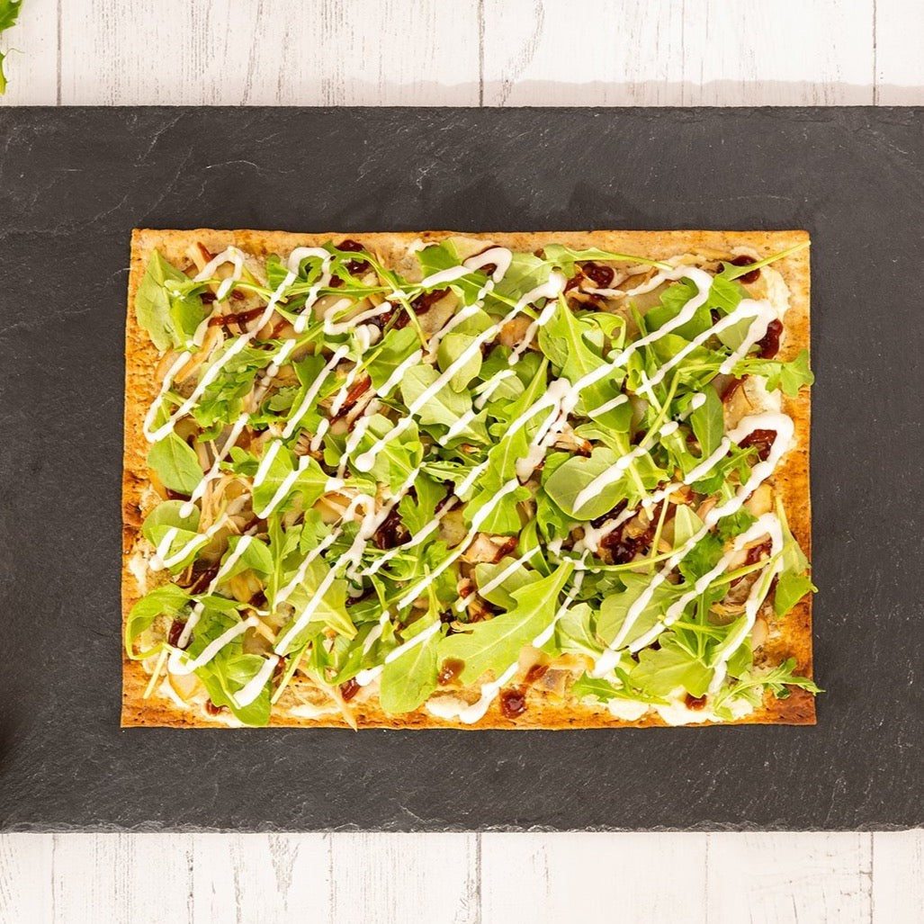 Joseph's Bakery Flax, Oat Bran & Whole Wheat Lavash Bread baked as a thin pizza topped with arugula on slate