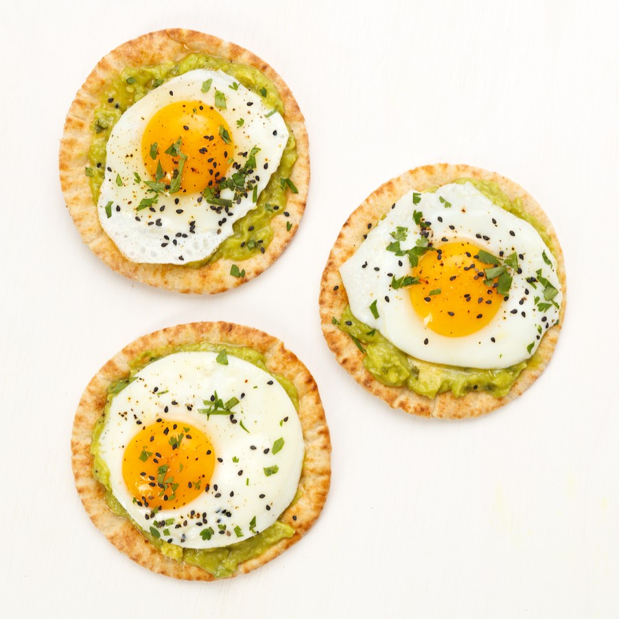 Joseph's Bakery Flax, Oat Bran & Whole Wheat Mini Pita Bread topped with avocado and fried eggs, overhead shot